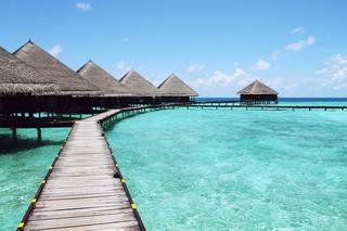 photo of thatched huts over turquoise water